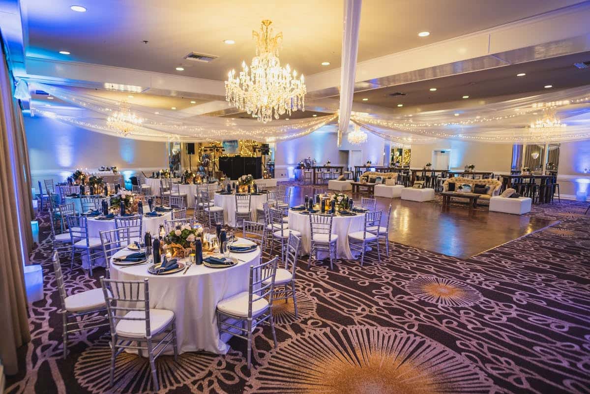 Social event with round tables and brightly lit chandeliers