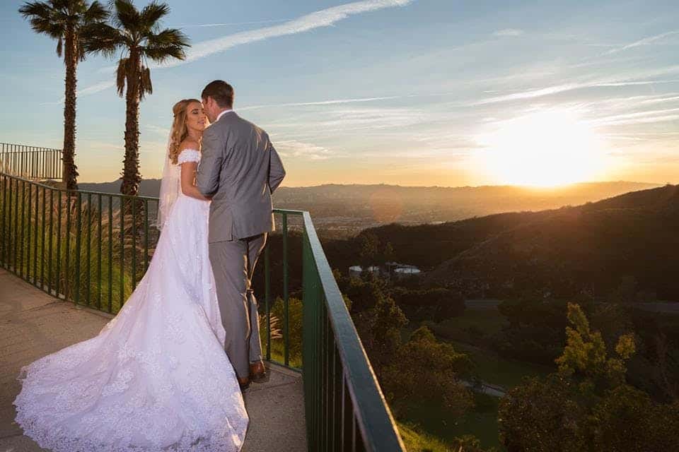 Newly married couple kissing in front of the sunset and mountains