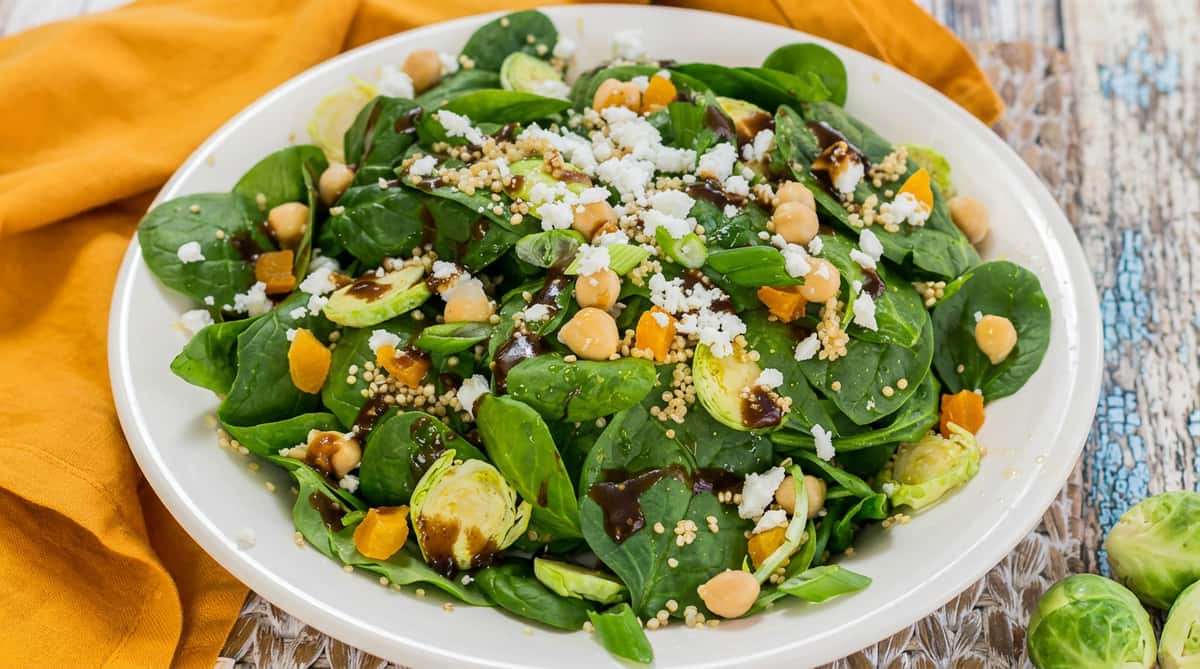Fresh spinach and roasted Brussels sprout salad topped with feta, pumpkin seeds, and sliced almonds at Chaat Diner, a pure vegetarian Indian restaurant in San Francisco.