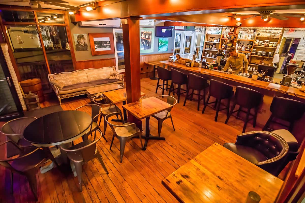 Warm wood interiors with bar seating and lounge tables, offering a relaxed setting for wine, craft beer, and coffee.