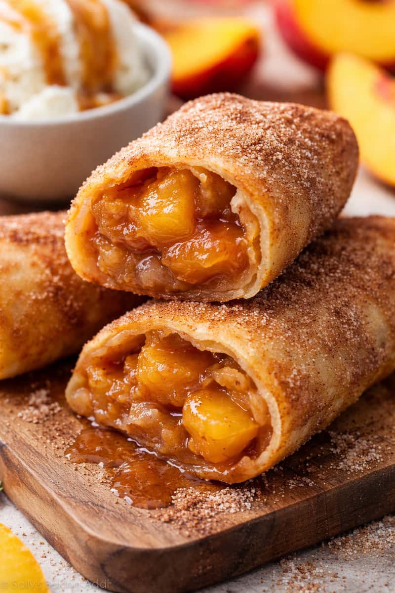 A warm, crispy egg roll filled with sweet, cinnamon-spiced peaches and buttery cobbler flavor, fried to golden perfection and finished with a light sugar dusting.