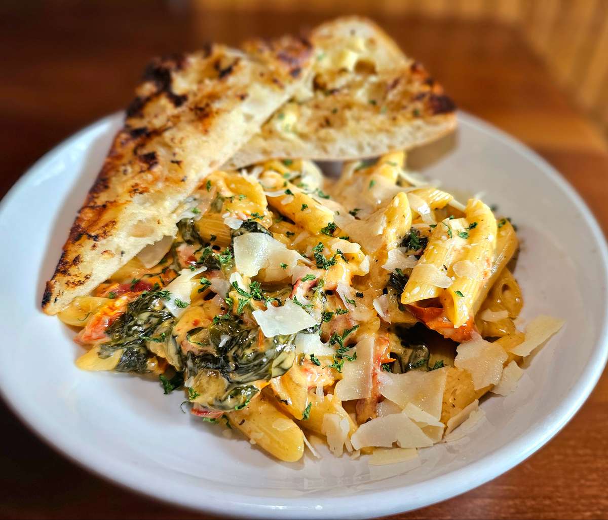 Creamy Tuscan Penne - Penne tossed in a garlic cream sauce with sun-dried tomatoes & spinach. Served with garlic bread.
