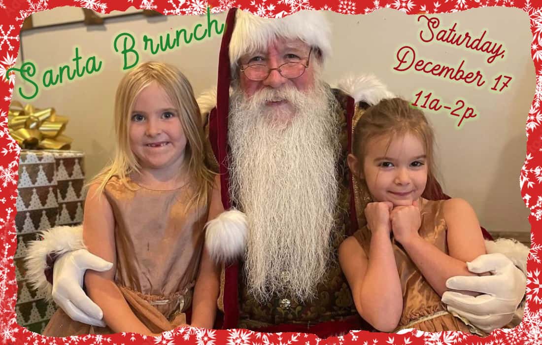 Santa on a bench with two little girls sitting on each side of him wearing gold dresses