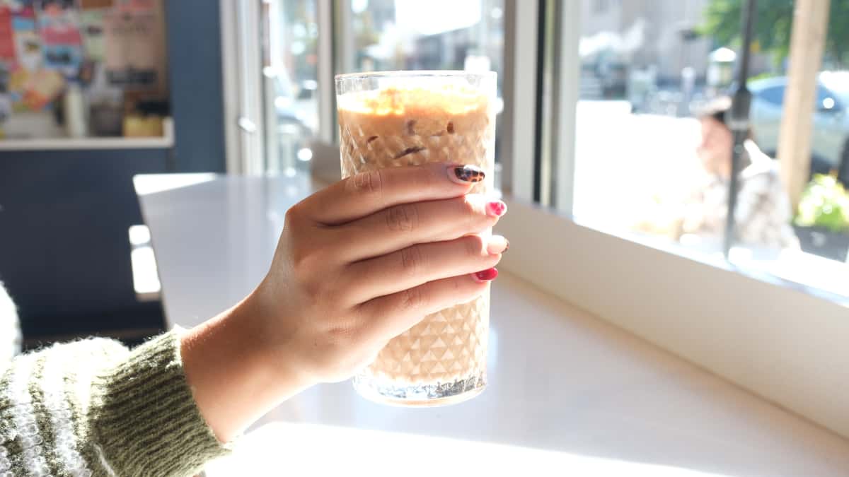 Hand holding a glass of coffee