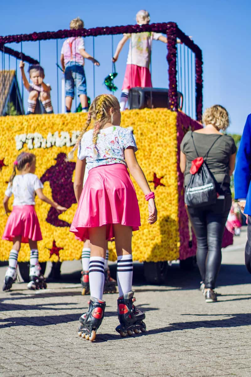 Kids on roller skates in a colorful parade