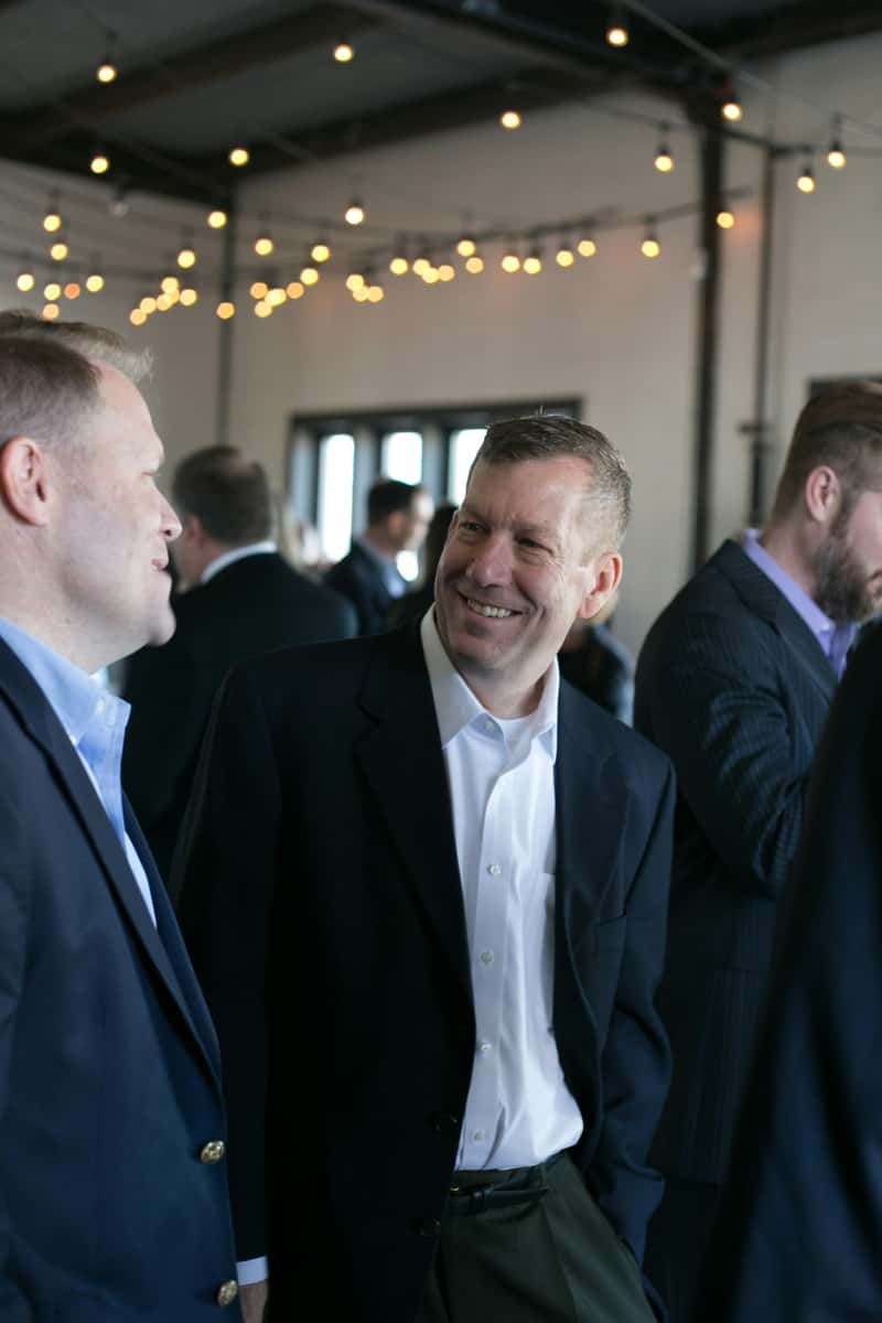 Men in suits talking at a business event