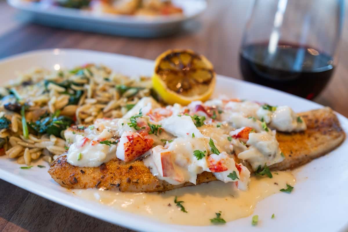 Blackened snapper fillet topped with crab and lobster cream sauce. Served with a side of black bean spinach orzo.