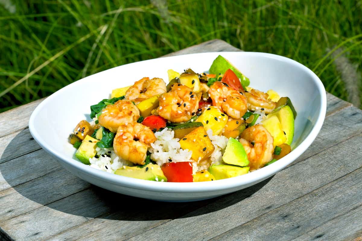 Fresh shrimp, squash, zucchini, peppers and pineapple, sautéed in a ginger-soy glaze. Served over sticky rice and spinach. Finished with diced avocados, green onions and sesame seeds