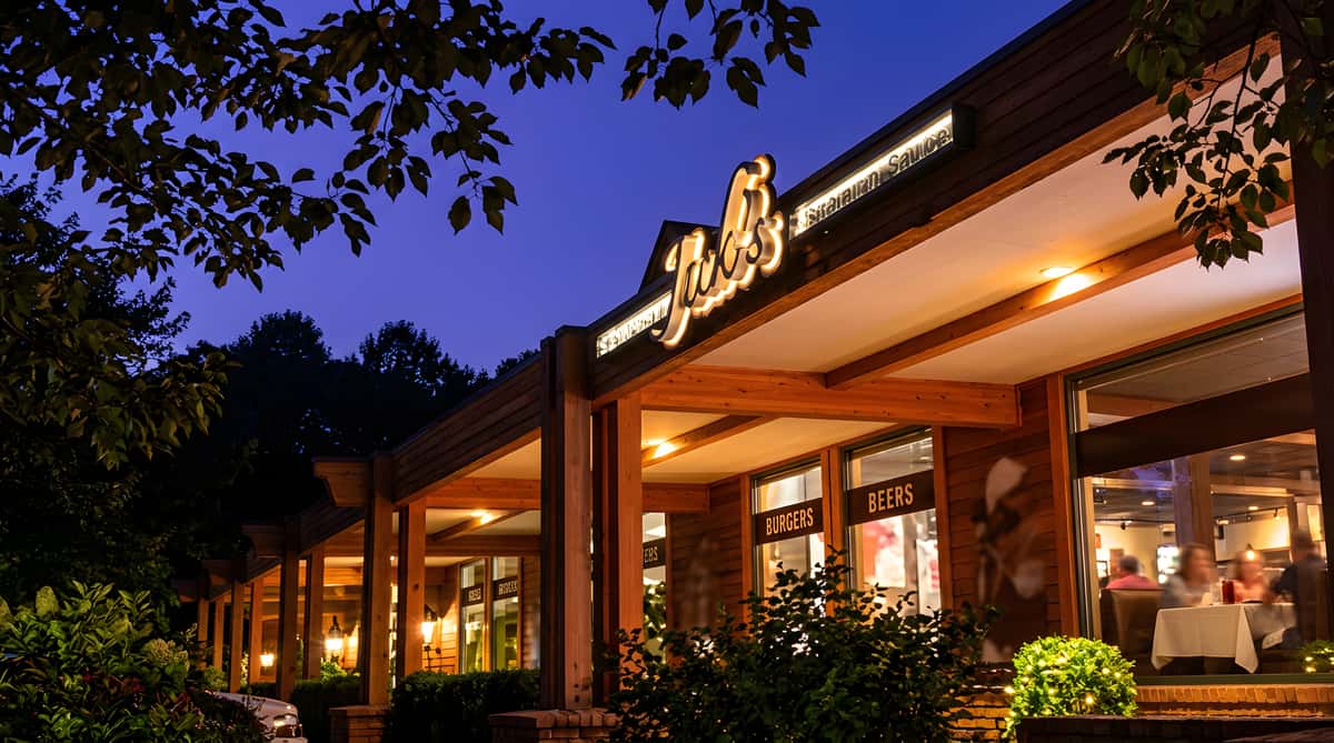 Exterior of Jack's restaurant at night, with its illuminated sign visible against a dark sky.