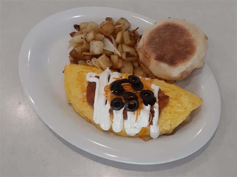 Omelette Ole: 3 egg omelet with green pepper, onion, sausage, homemade salsa and cheddar. Topped with sour cream, salsa and black olives. Served with home fries and a biscuit.