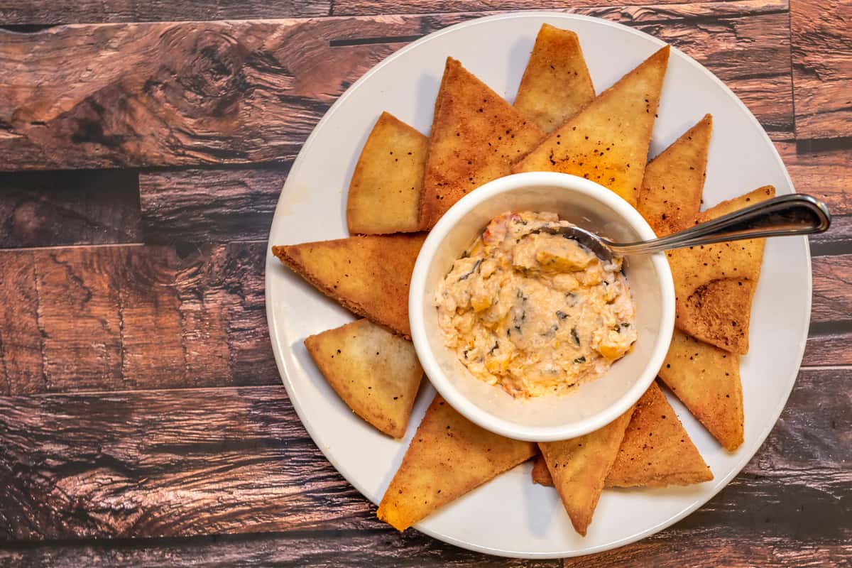 ATTN! (Oil Contains, Flour, Milk, Eggs and Fried with other meats) We start with our fresh collards and add three kinds of cheese, onions, tomatoes, sour cream, and seasoning served piping hot with deep fried pita chips.