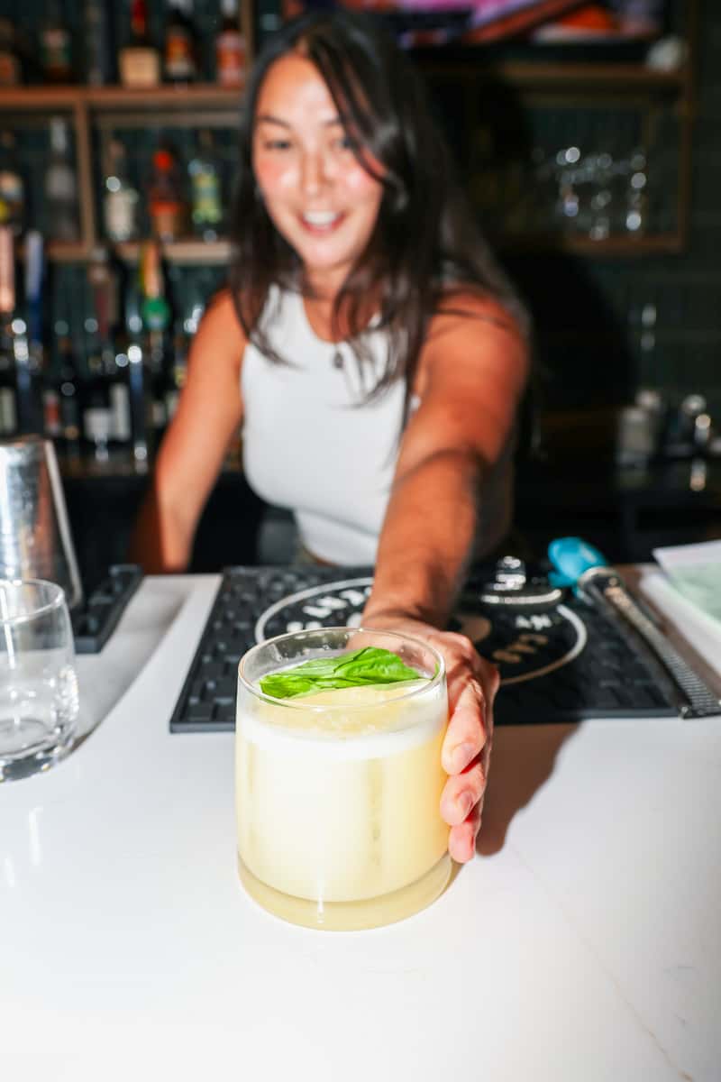 Bartender serving a craft cocktail at Lounge 832
