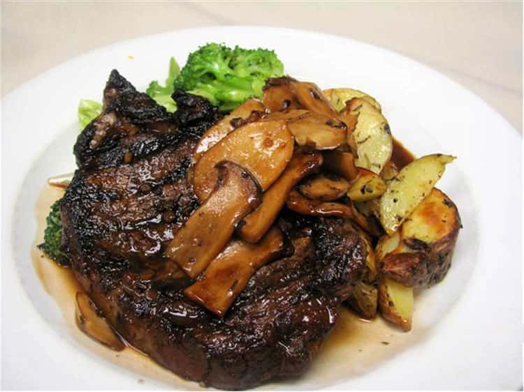 Grilled steak topped with sautéed mushrooms, served with roasted potatoes and steamed broccoli.