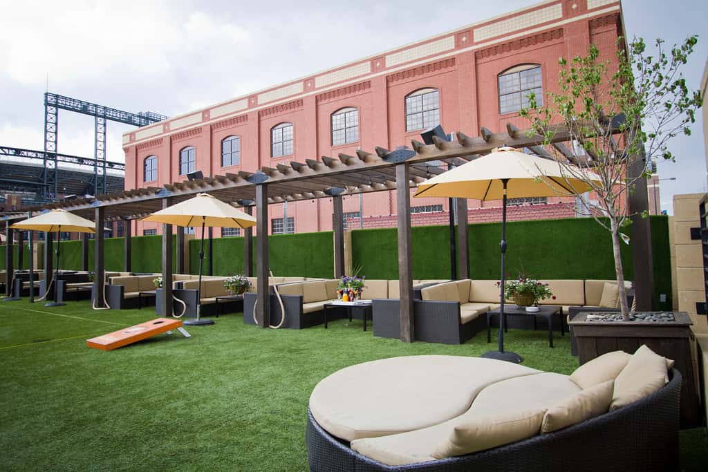 Outdoor lawn lounge with pergola seating, umbrellas, yard games, and flexible event space for gatherings and private parties.