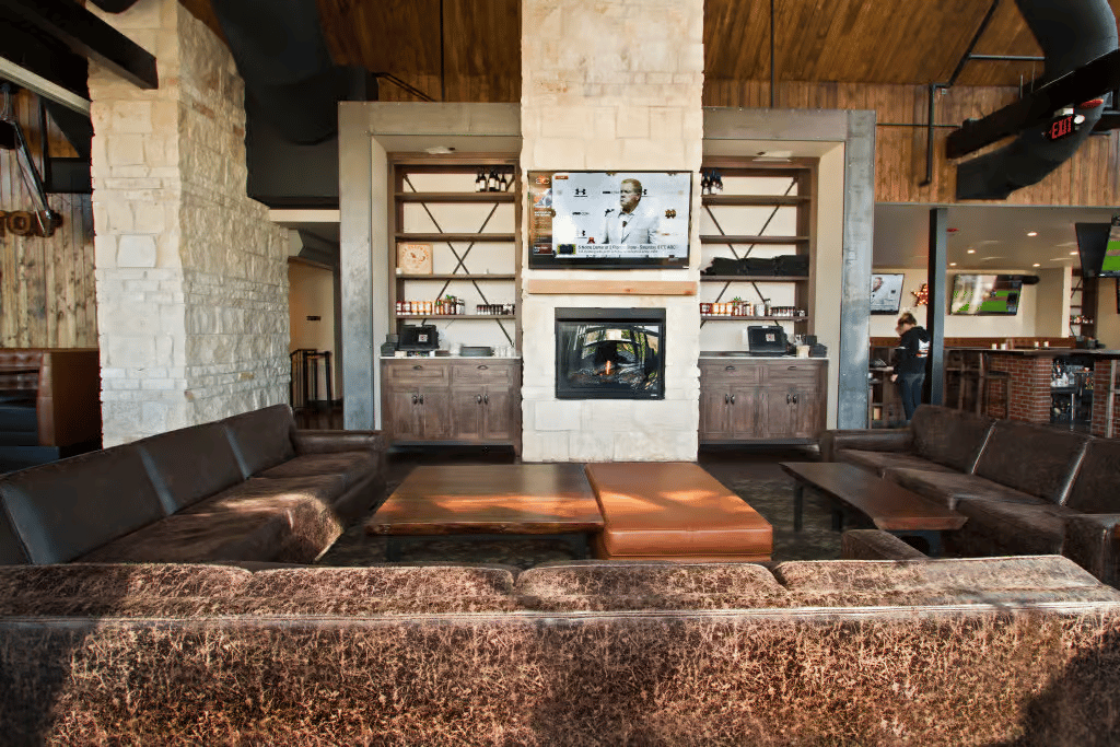 Comfortable restaurant lounge with fireplace, television, and plush seating for relaxing, socializing, and private gatherings.