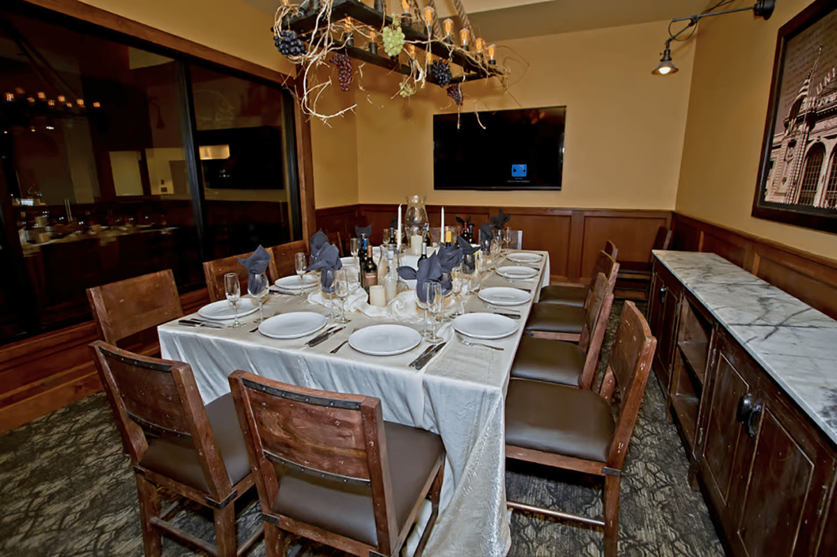Private dining room with elegant table settings, wood furnishings, and intimate seating for business dinners, celebrations, and special events.