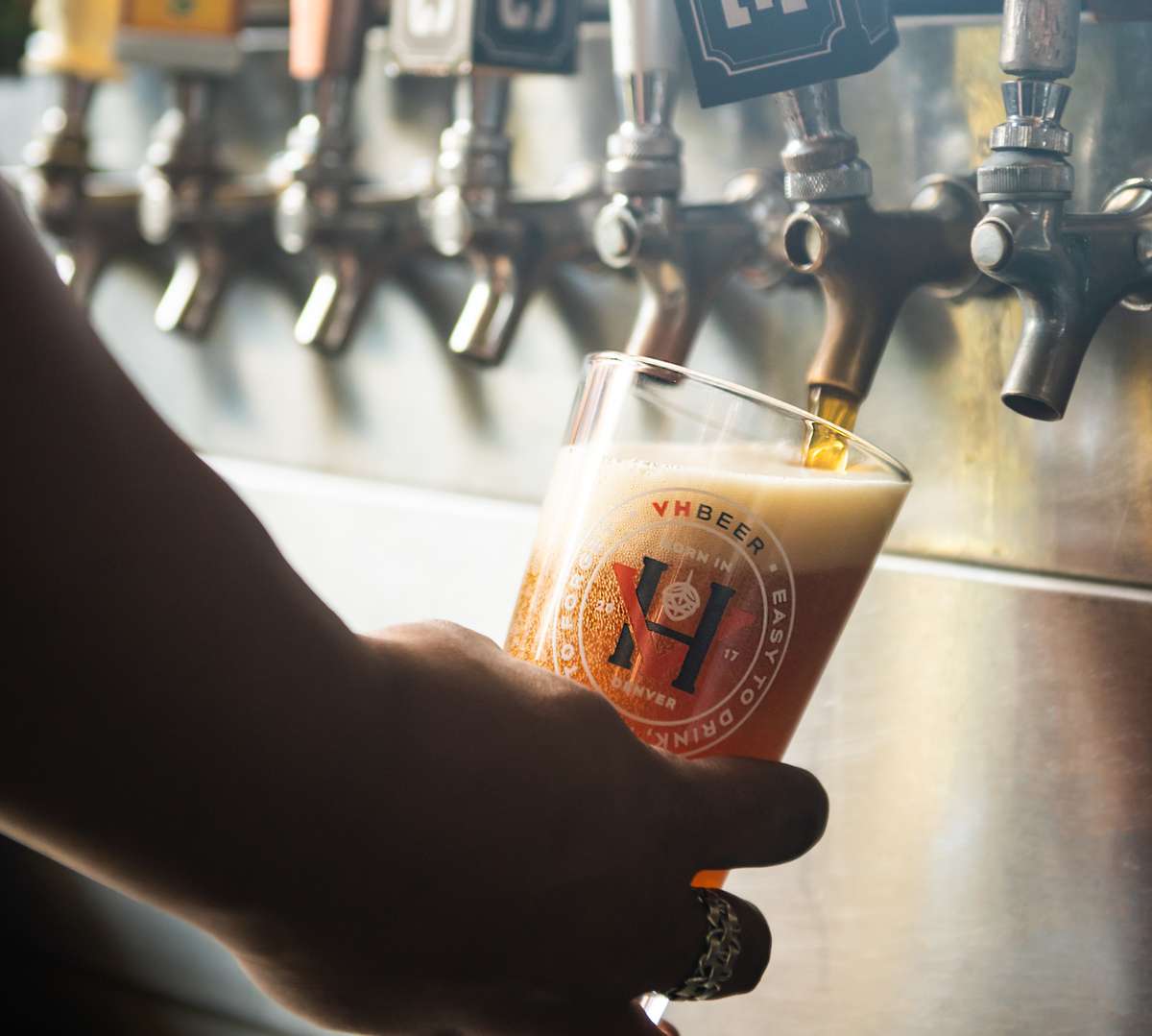 Person filling glass with beer