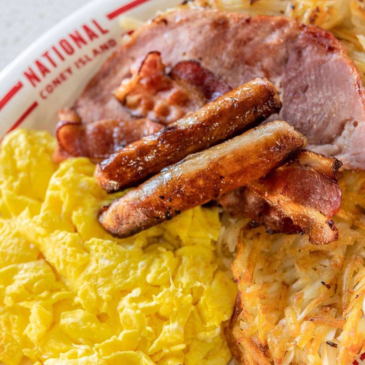 Big Breakfast with sausage, eggs, bacon and potatoes plate