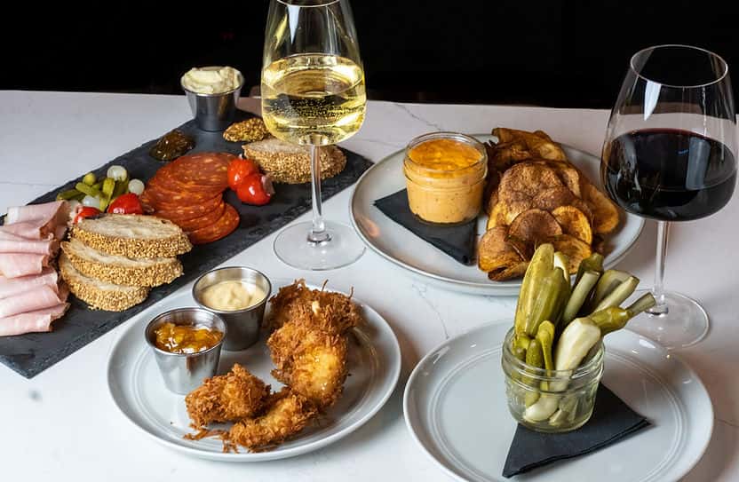 spread of menu items with glass of white wine