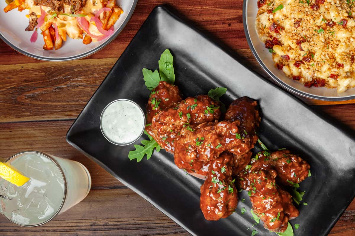 Appetizer of saucy meat topped with garnish and served with a sauce