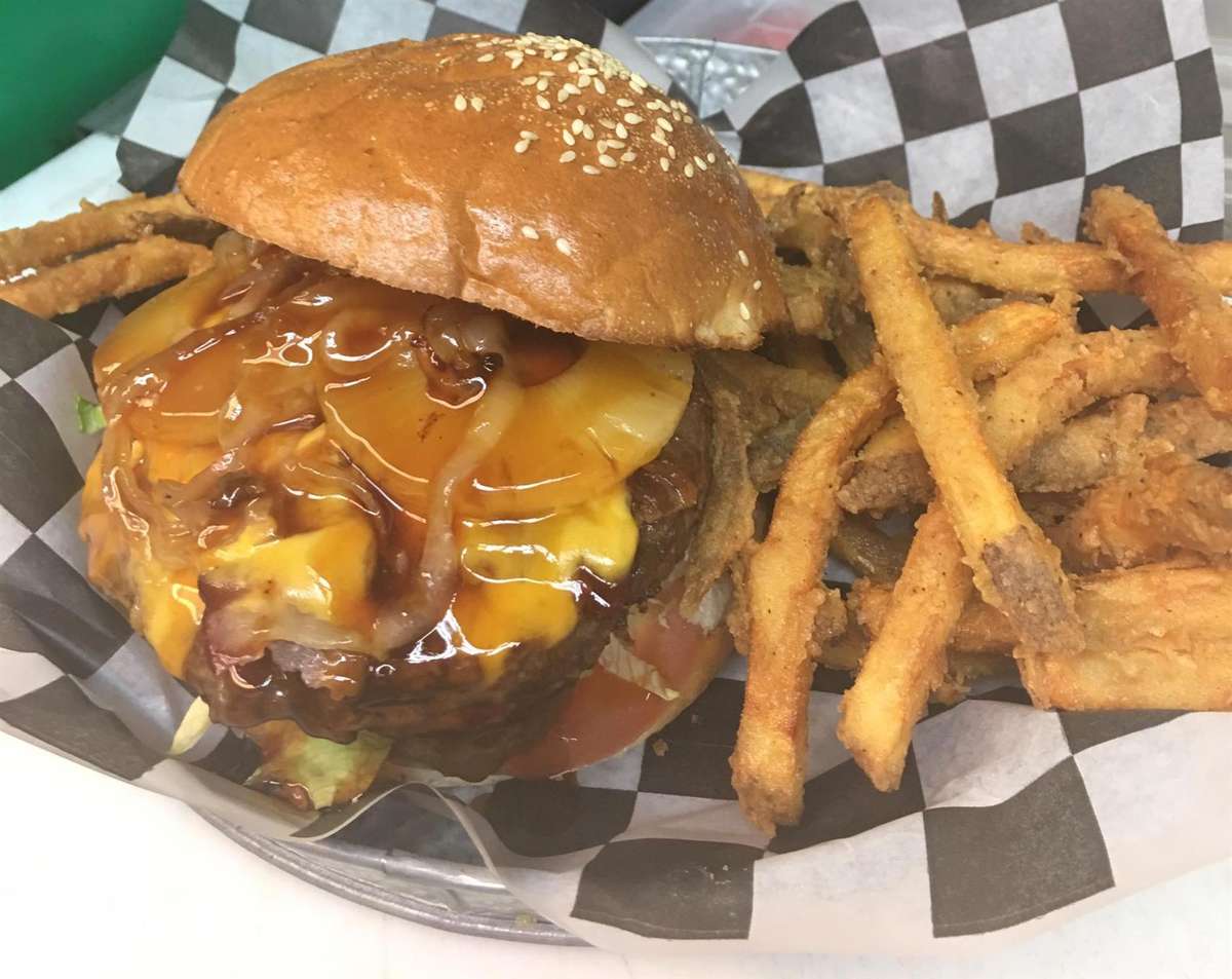 double cheeseburger with lettuce, tomatoes, and mushrooms with fries on the side