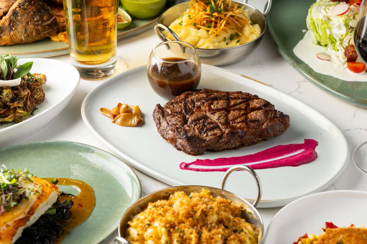 steak and mac and cheese on a plate on a table