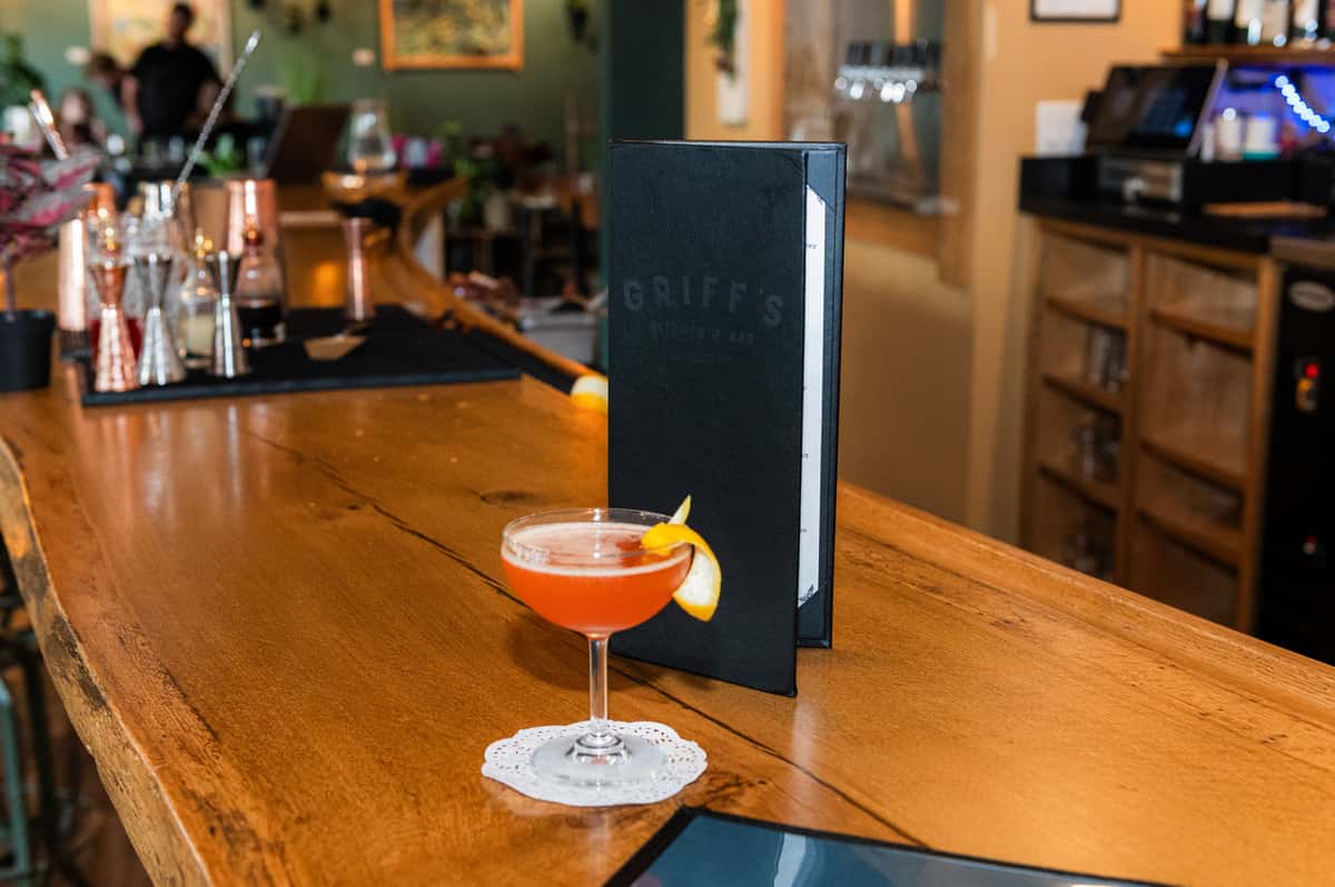 Cocktail at the bar at Griff's Kitchen & Bar in Candler, NC with dinner and drink menus