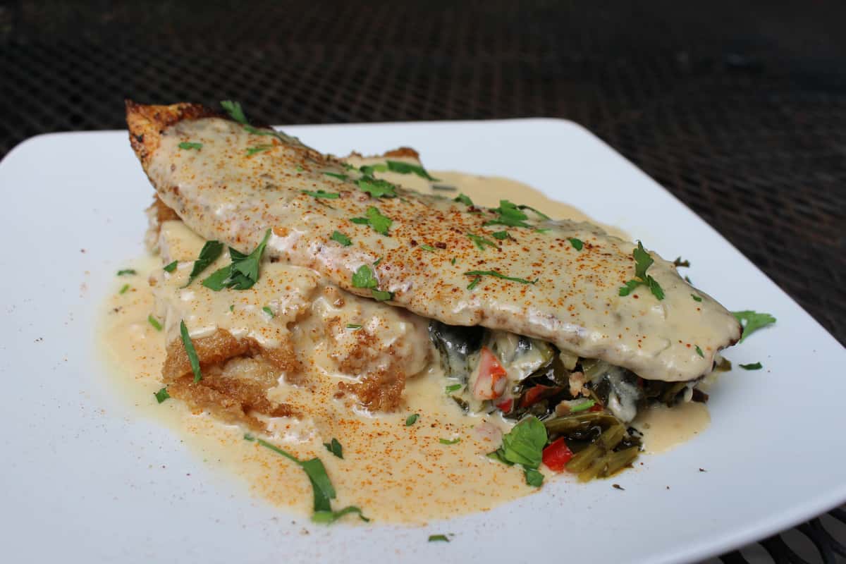 blackened Red Fish, fried grit cake, collard greens, lobster sherry cream sauce.