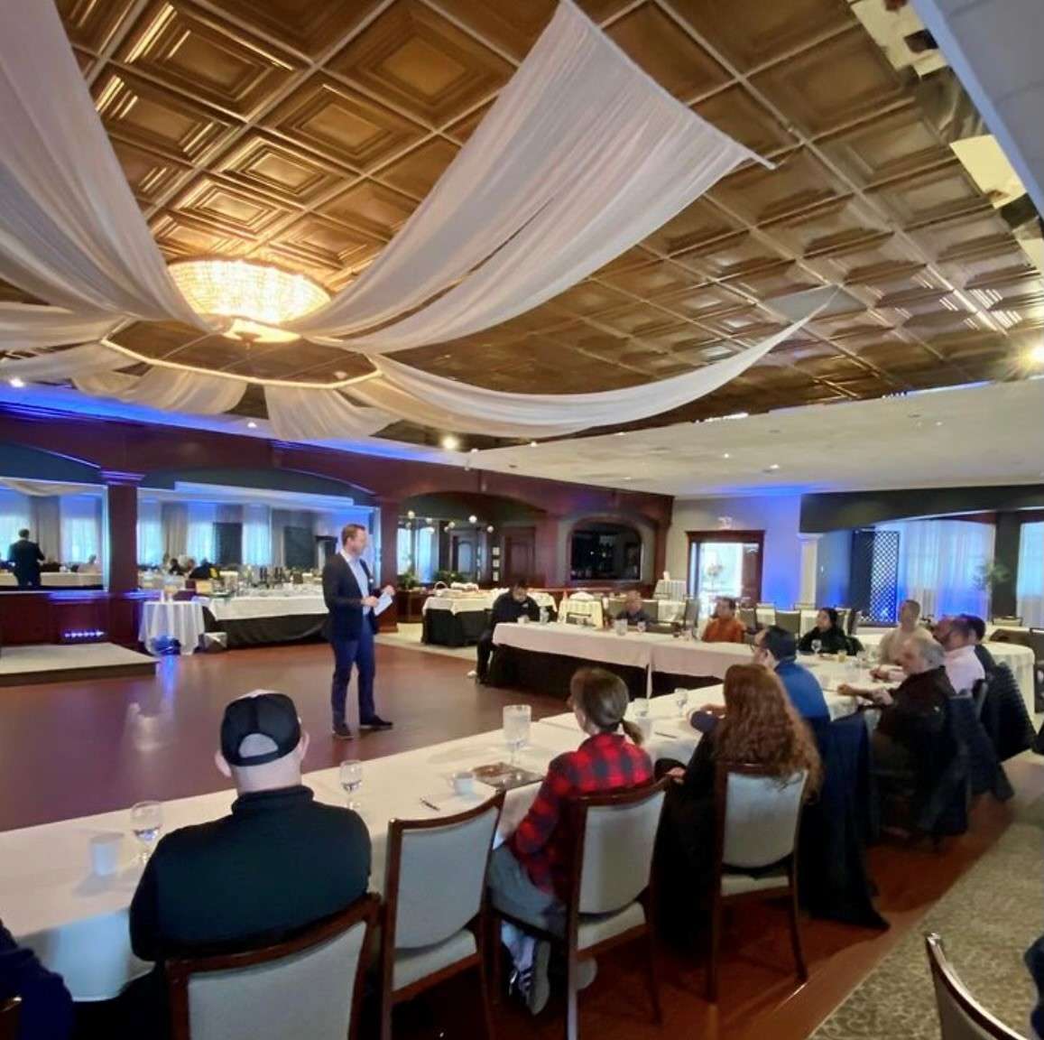 Speaker Talking to Group of People at Tables