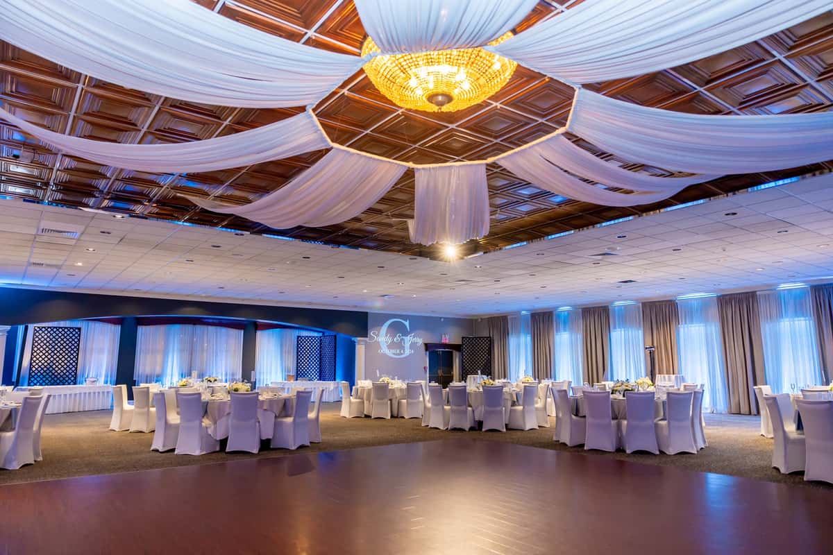 Ballroom with white chairs and drapes