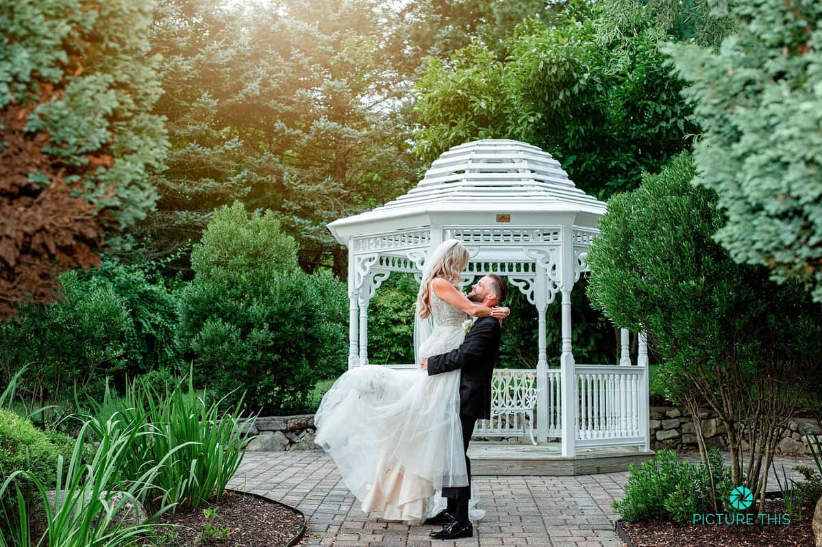 Groom picking up bride outdoors