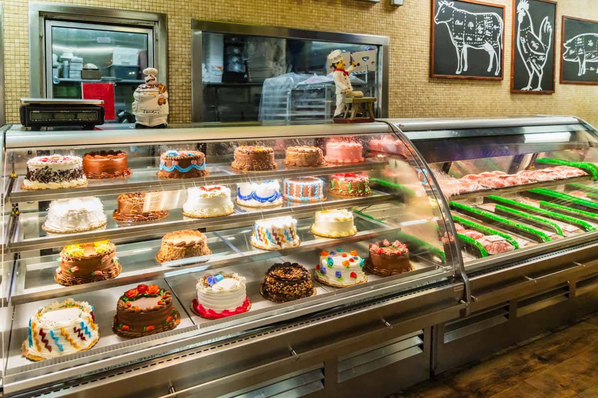 A deli and bakery display case filled with a variety of meats and prepared foods at The Butcher Shop