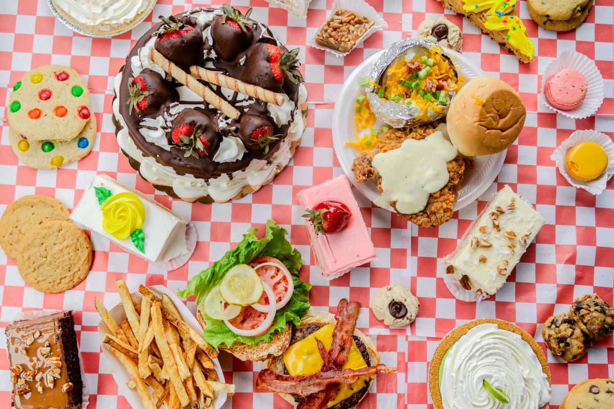 An overhead view of a variety of food dishes served at The Butcher Shop restaurant, displayed on a checkered tablecloth