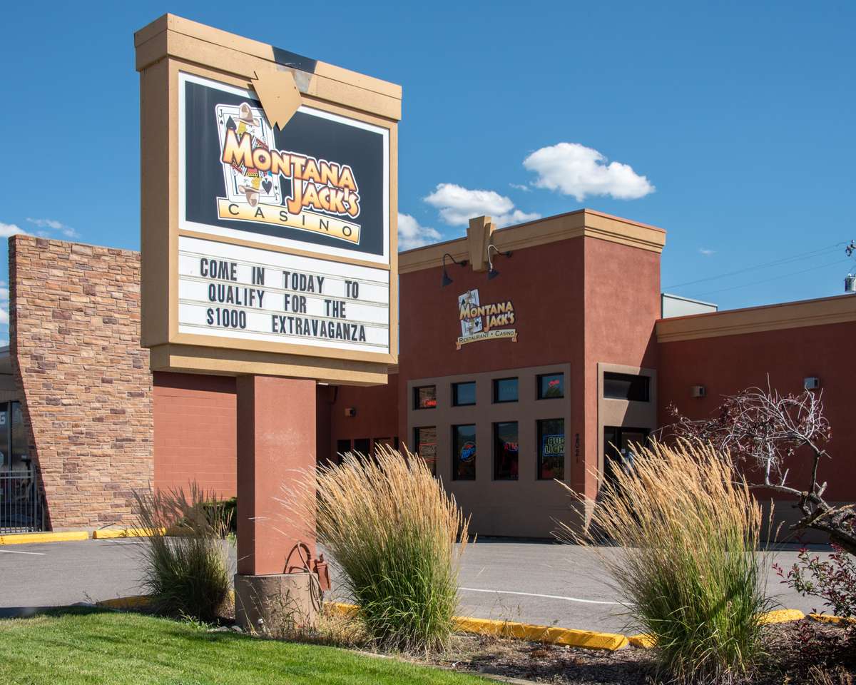 Front entrance of Montana Jack's Restaurant and Casino in Missoula with promotional signage and landscaped grounds.