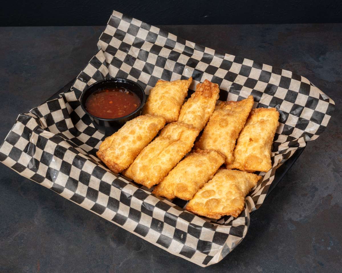 Golden-brown shrimp and cream cheese wontons served in a basket with sweet chili sauce for dipping.