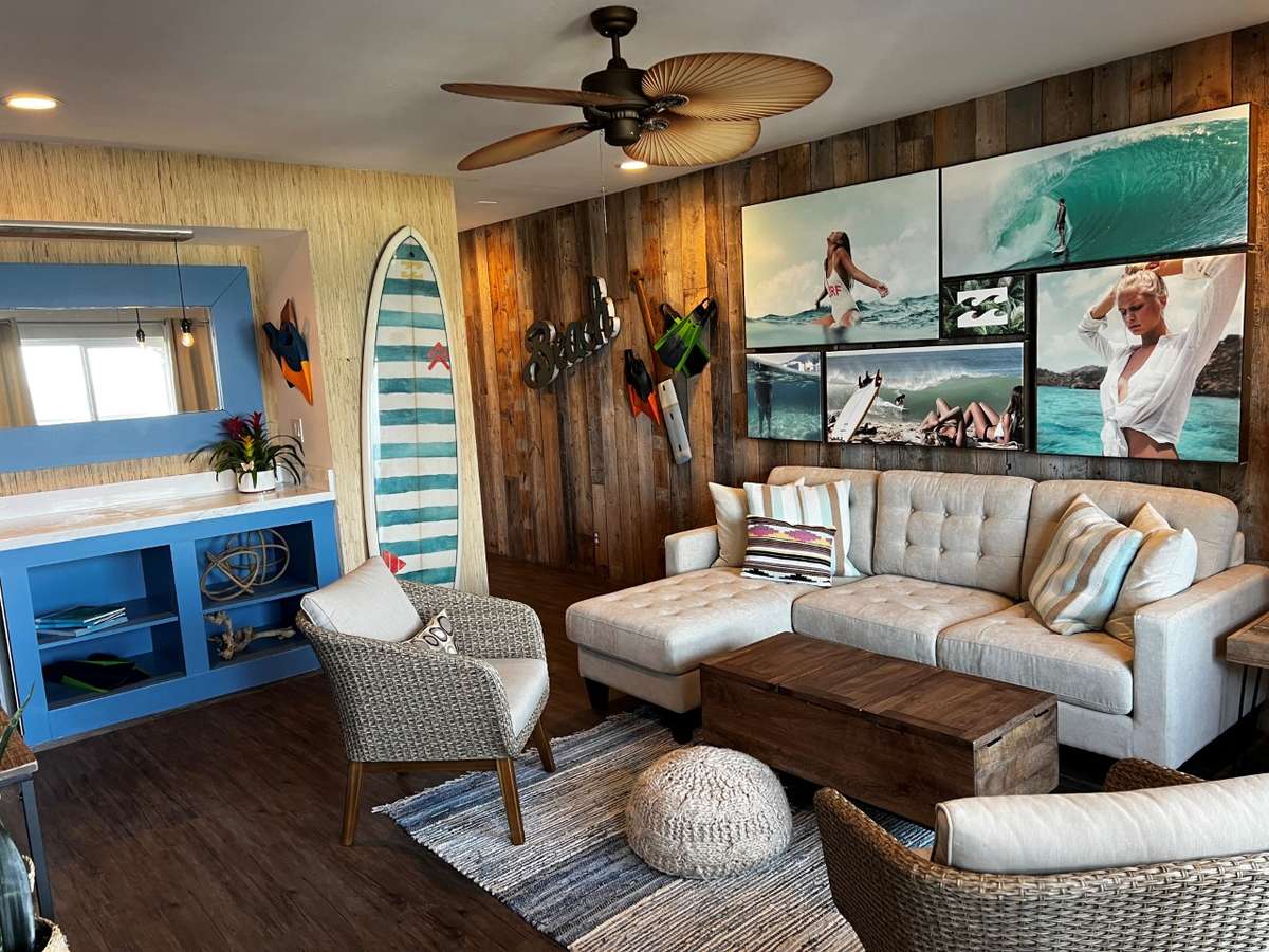 pic of room with couch, wall art and surfboard