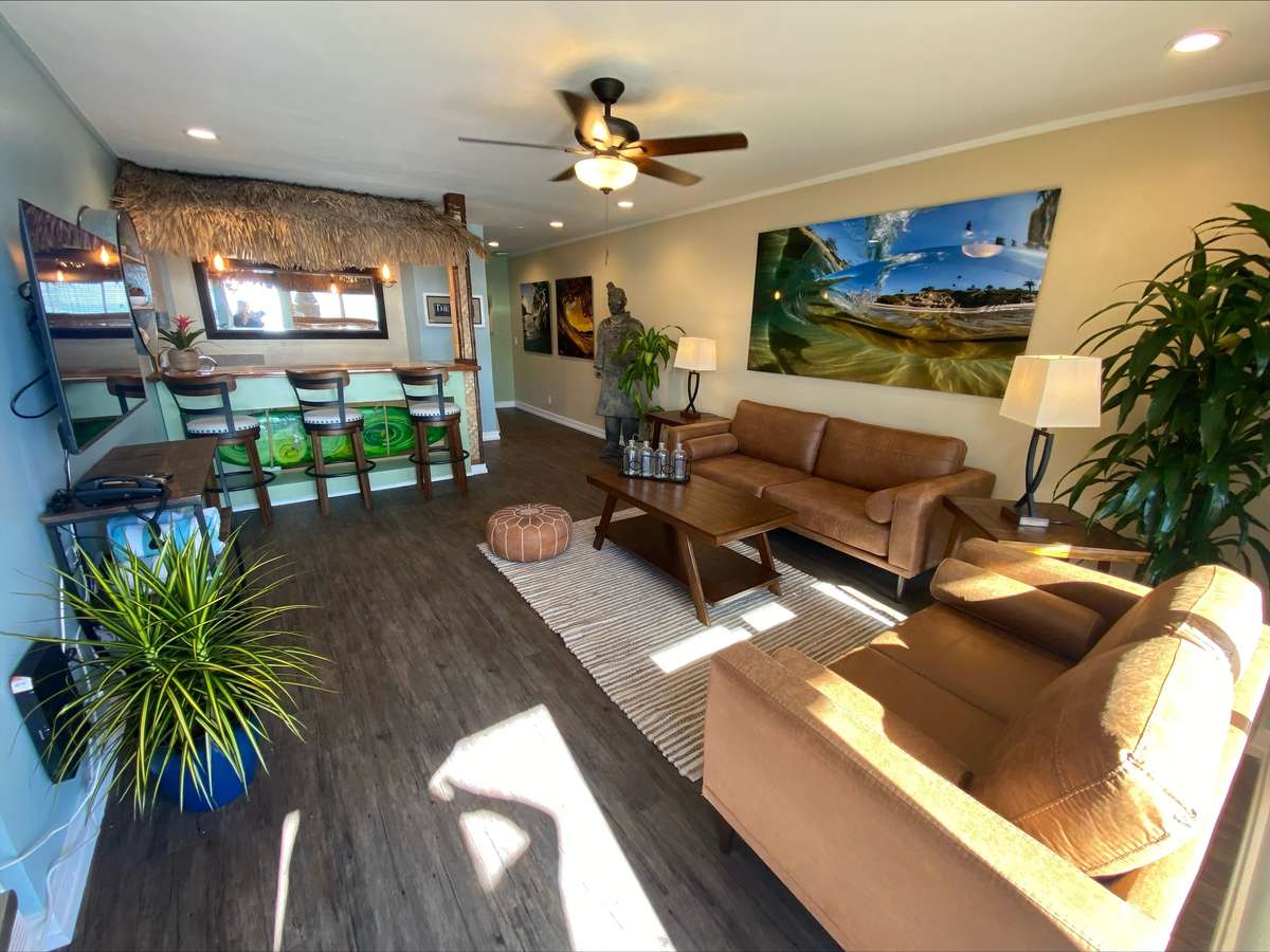 inside the tiki bungalow, couch, bar, coffee table and chairs