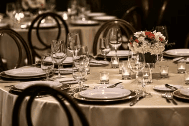 Upscale fine dining table setting with wine glasses, candles, and elegant restaurant event decor