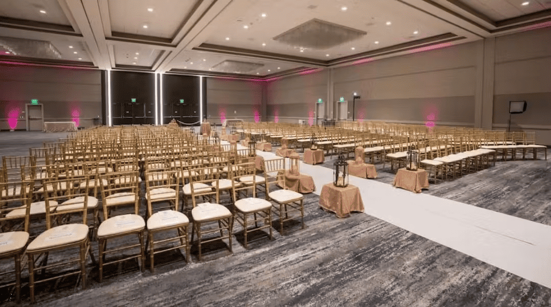 Modern conference ballroom with rows of seating, stage lighting, and upscale corporate event setup