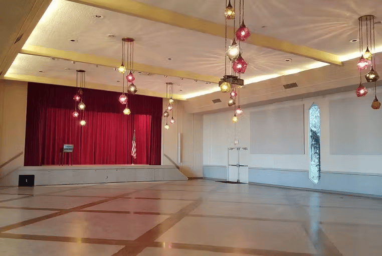 Modern event hall with open dance floor, pendant lighting, and contemporary banquet venue design