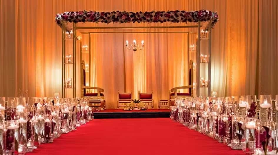 Luxury wedding stage with red carpet aisle, elegant drapery, and romantic reception decor