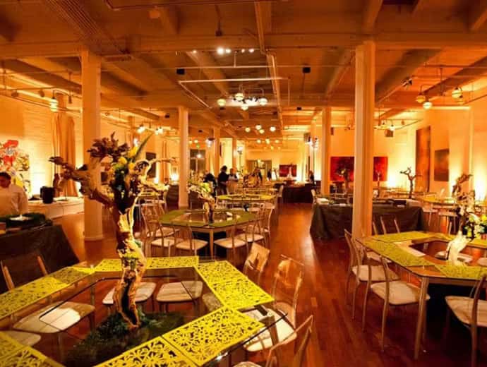 Warmly lit upscale restaurant interior with elegant dining tables, wood accents, and sophisticated event atmosphere