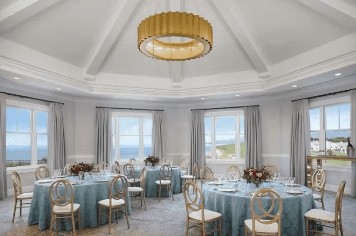 Elegant private dining room with gold chandeliers, round tables, and upscale event seating in a luxury venue