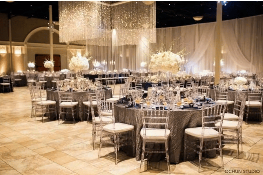 Luxury ballroom reception with crystal chandeliers, round dining tables, and elegant formal event decor