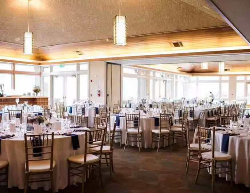Bright contemporary ballroom with elegant banquet seating, natural lighting, and upscale event decor