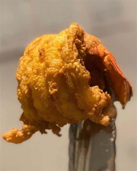 fried shrimp held by tongs