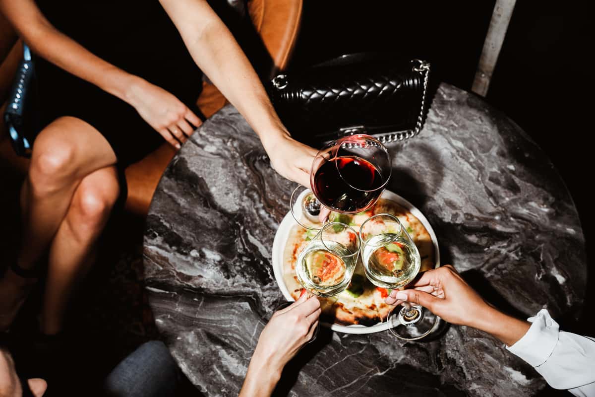 toasting with red wine over pizza