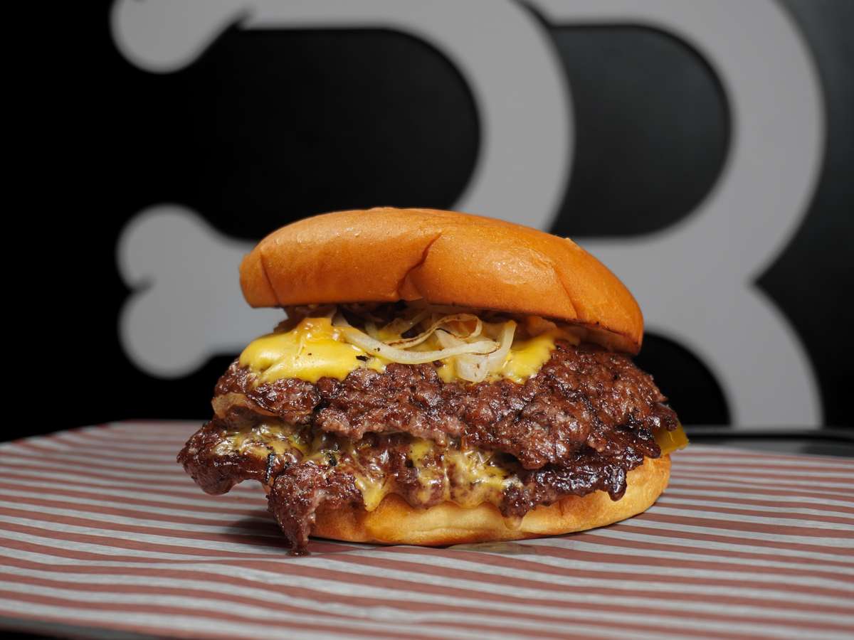 Double smash cheeseburger with crispy beef patties, melted cheese, and grilled onions on a soft brioche bun