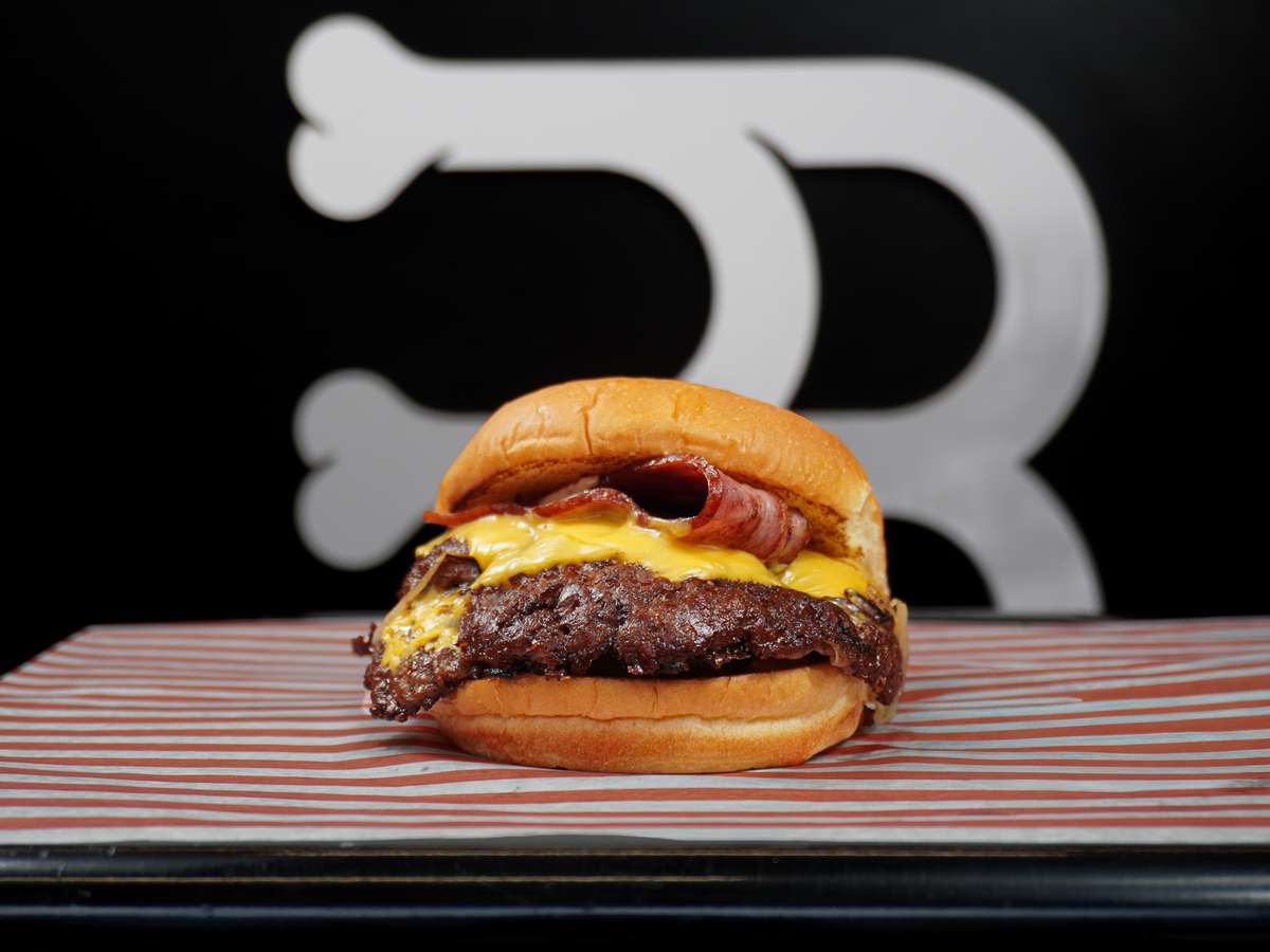 Smash burger with crispy beef patty, melted cheese, and bacon on a soft toasted bun