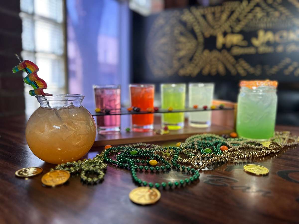 Festive image used for the website header. It displays several bright colored cocktails, Mardi Gras beads and coins, and text "Mr. Jackson's".